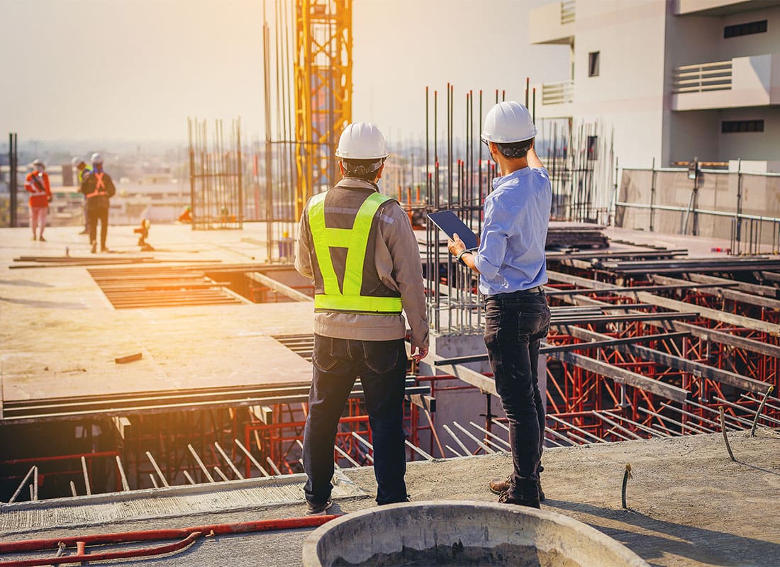 Insurance by Industry - Structural Engineer and Foreman Worker With Tablet Discussing Plans